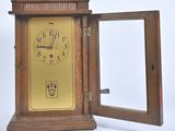 a small wooden clock with a mirror in it