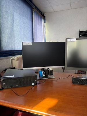 un bureau sur lequel sont posés deux écrans et un ordinateur portable