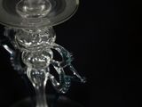 a glass candle holder that has a candle on top of it