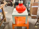 a red vase sitting on top of a table in a store