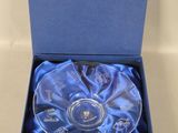 an empty glass bowl in a blue box on a white surface