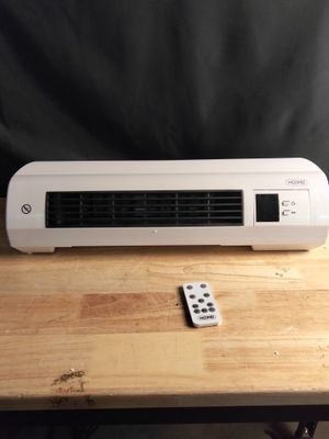 un climatiseur posé sur une table en bois, à côté d'une télécommande