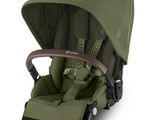 the buggy stroller has a green seat and a brown handlebar