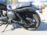a black motorcycle parked in a parking lot next to a car
