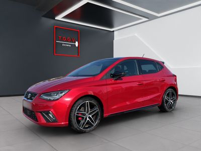 a red seat ibe car parked in a showroom