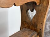 a wooden bench with a heart carved in the back