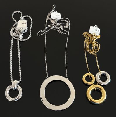 un ensemble de trois colliers posés sur un fond noir