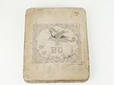 un vieux livre posé sur une table blanche à côté d'un mur blanc