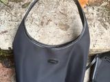 a black purse and a black purse sitting on the ground