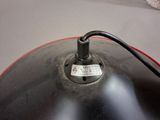 a close up of a black lamp with a red cord