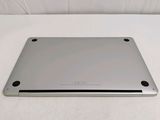 the back of a silver laptop sitting on top of a white surface