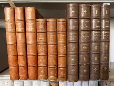 Plusieurs vieux livres sont empilés sur une étagère dans une bibliothèque