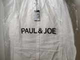 un gros plan sur une veste en plastique suspendue à un cintre accroché au mur
