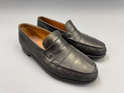 une paire de mocassins noirs sur fond blanc