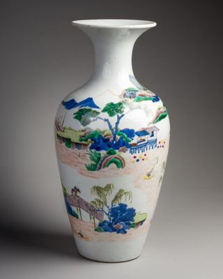un vase blanc avec un tableau posé sur une table