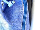 a blue purse that is sitting on a white surface
