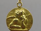a close up of a gold coin with an angel on it