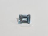 an aquamarine blue topazte stone on a white surface