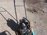 a lawn mower that is sitting on the ground next to a car
