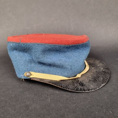 une image représentant un chapeau bleu orné d'un ruban rouge