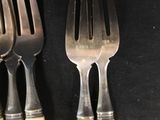 three forks that are sitting next to each other on a table