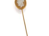 a close up of a gold plated broochle with a woman ' s face