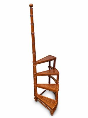 un escalier en colimaçon en bois adossé à un mur blanc