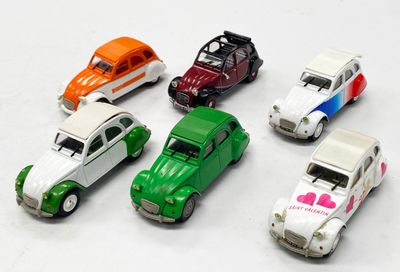plusieurs petites voitures sont alignées sur une surface blanche