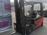a forklift truck that is parked next to a stack of pallets