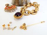 de nombreux bijoux posés sur une table, avec un vase en arrière-plan