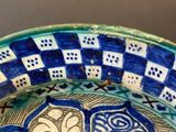 a blue and white bowl with designs on it