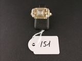 gros plan d'une bague sur une surface noire avec une étiquette de prix