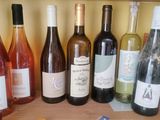 several bottles of wine are lined up on a wooden shelf