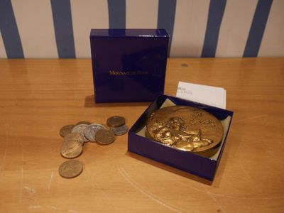 une boîte contenant quelques pièces et une carte, posée sur une table