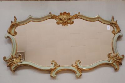 un miroir avec un cadre doré sur le mur
