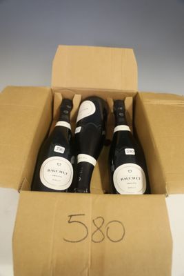trois bouteilles de vin dans un carton sur une table