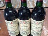 trois bouteilles de vin posées sur une table en bois