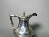 silver plated coffee pot with handle on grey background