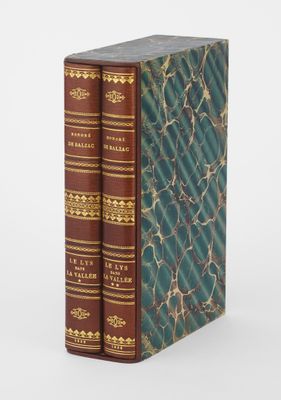 deux livres posés l'un sur l'autre sur une surface blanche