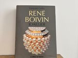 the book is sitting on a table next to a pair of pearls