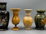 cinq vases alignés sur une surface grise