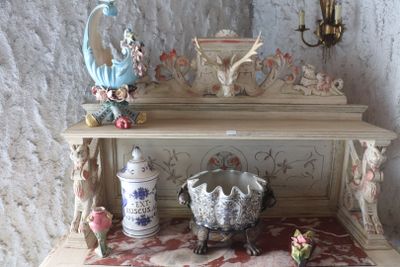 a small shelf with a vase on top of it