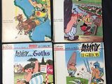 four children ' s cartoon books are lined up on a black surface