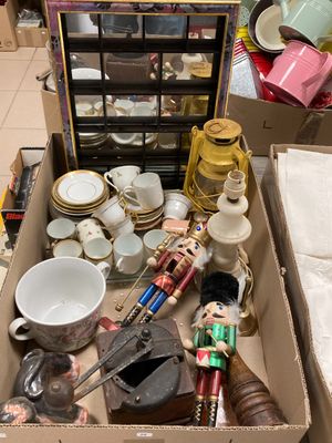 une boîte remplie d'objets hétéroclites posée sur le sol