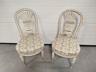 pair of white painted chairs with upholstered seat cushions