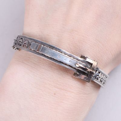 bracelet en argent orné d'une croix au poignet d'une femme