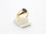 Gros plan sur une bague en or ornée d'une pierre noire