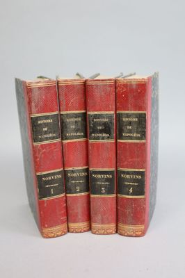 three red books sitting on top of each other on a white surface
