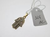 un gros plan sur une petite main de Hamsa en or sertie de diamants