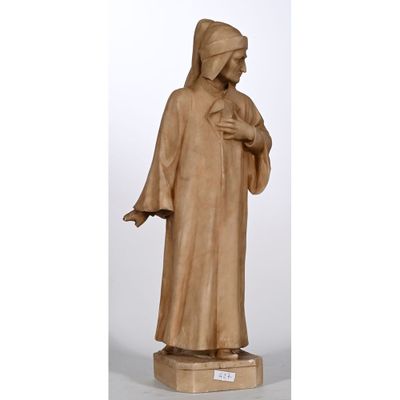 une statue représentant une femme vêtue d'une robe marron, tenant sa main